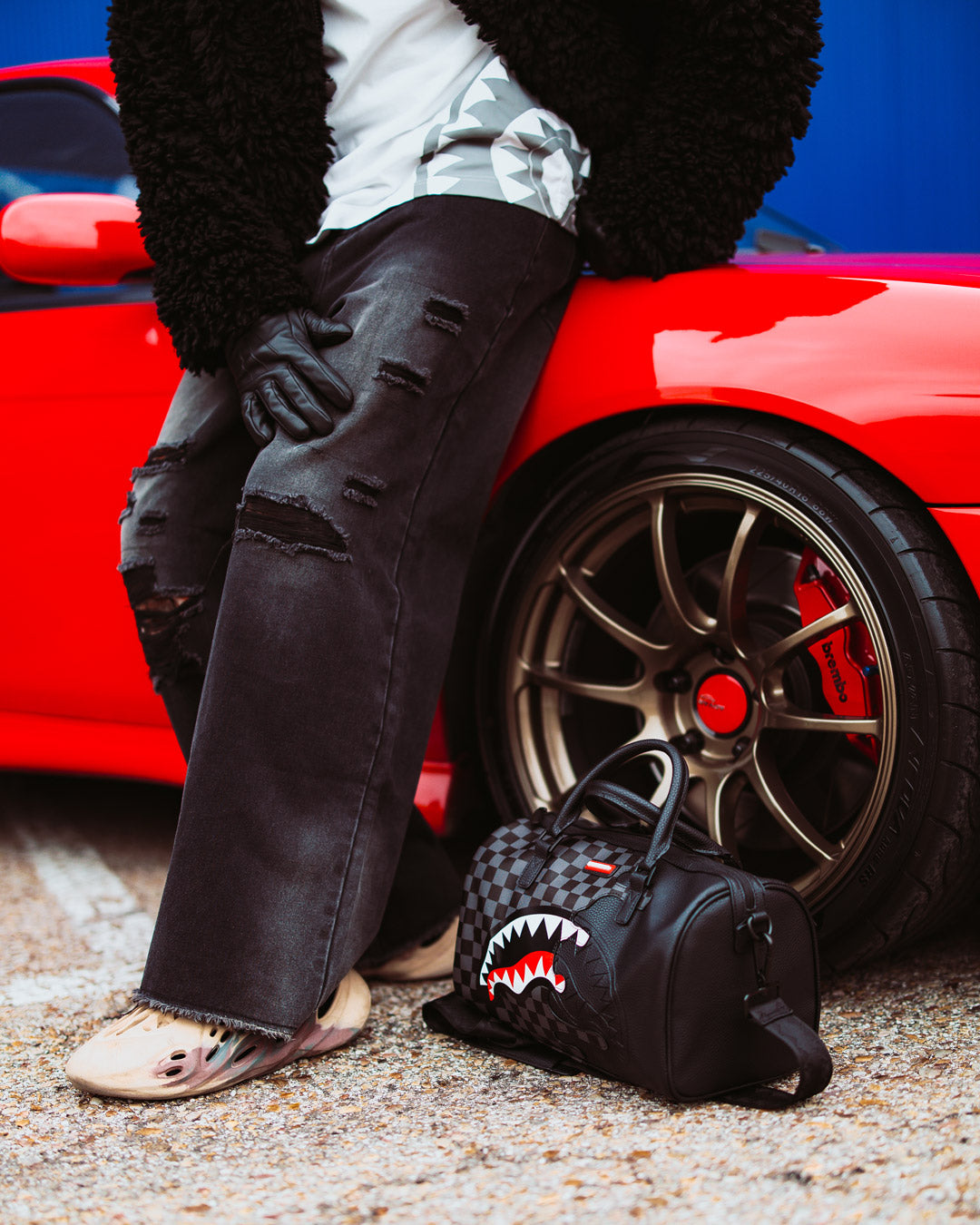 Side view of the mini duffle bag with crossbody strap and interior pockets.