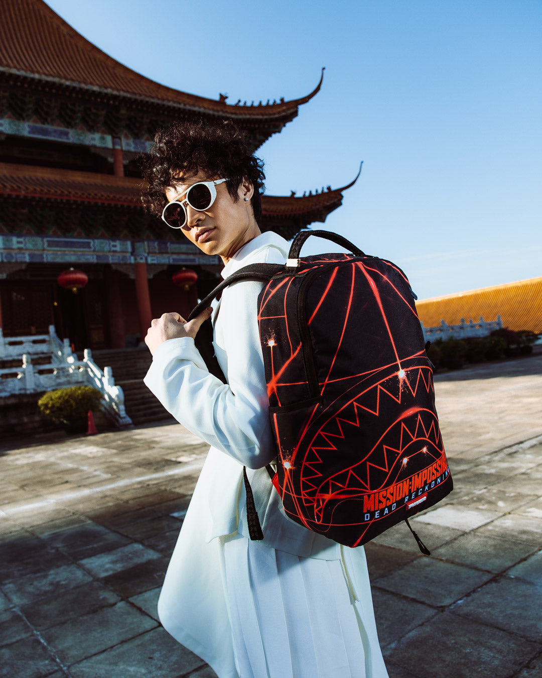 Sprayground Shark Backpack in pink, highlighting its adjustable straps and gold zippers with metal hardware.