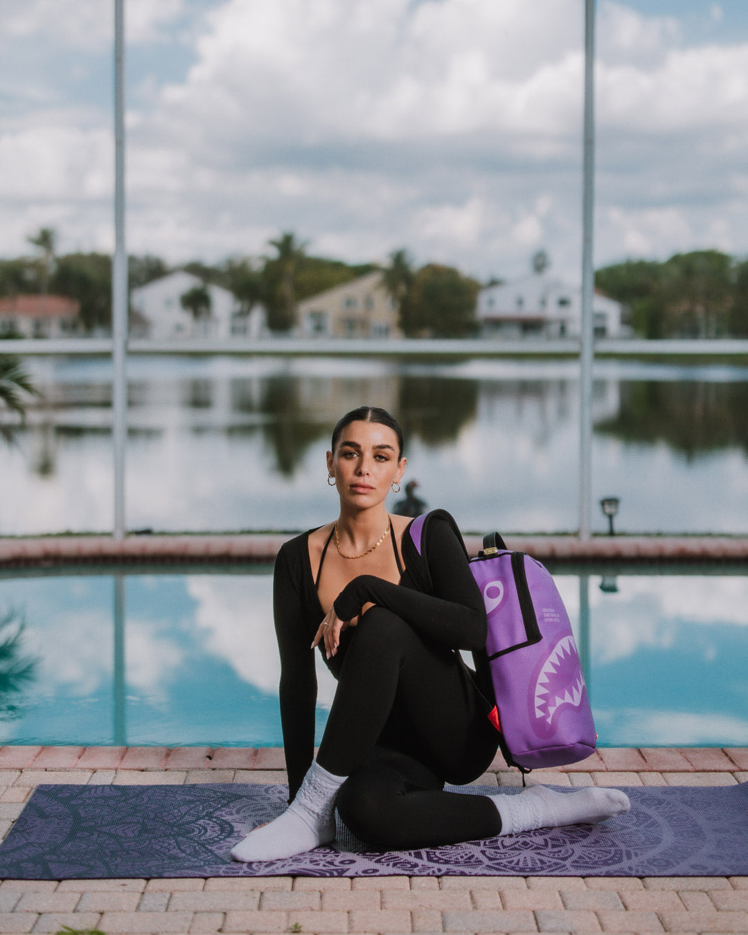 Side view of the fashion backpack highlighting gold metal zippers and adjustable straps.