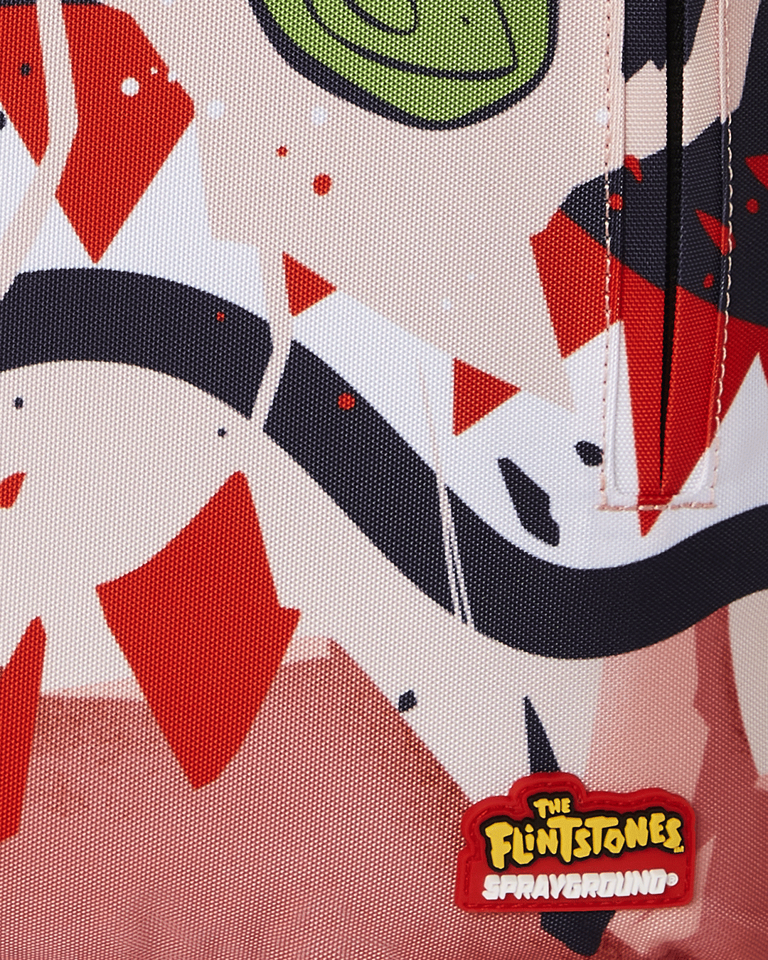 Close-up of the metal Sprayground Authentic badge on the Bamm Bamm Flintstones backpack