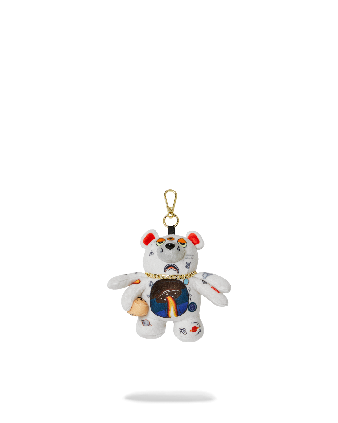 Close-up of a plush bear keychain with gold chain hanging from a backpack