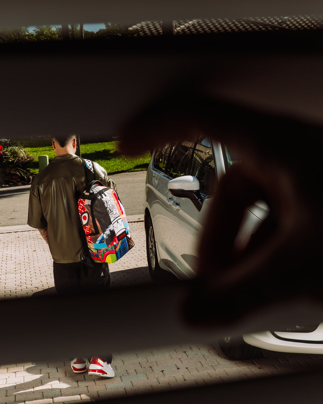 Open DLXV backpack showcasing laptop sleeve and mesh organization pockets