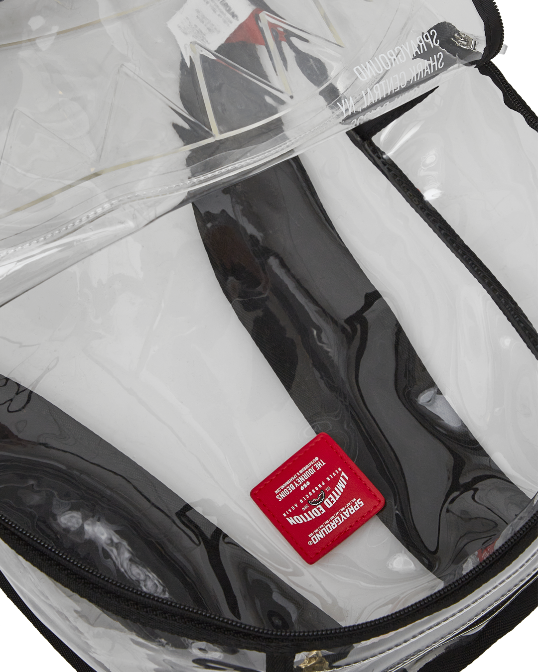 Clear Sprayground shark backpack worn on back, showing off its transparent PVC material and multiple pockets.