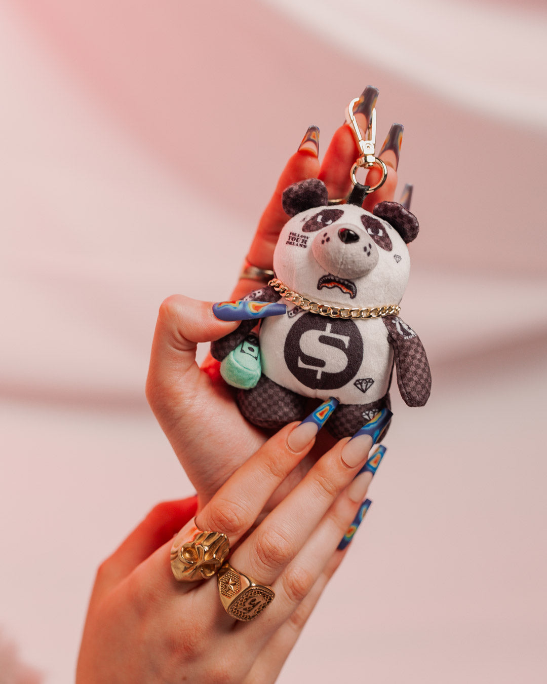 Close-up of the plush teddy bear keychain with gold chain.