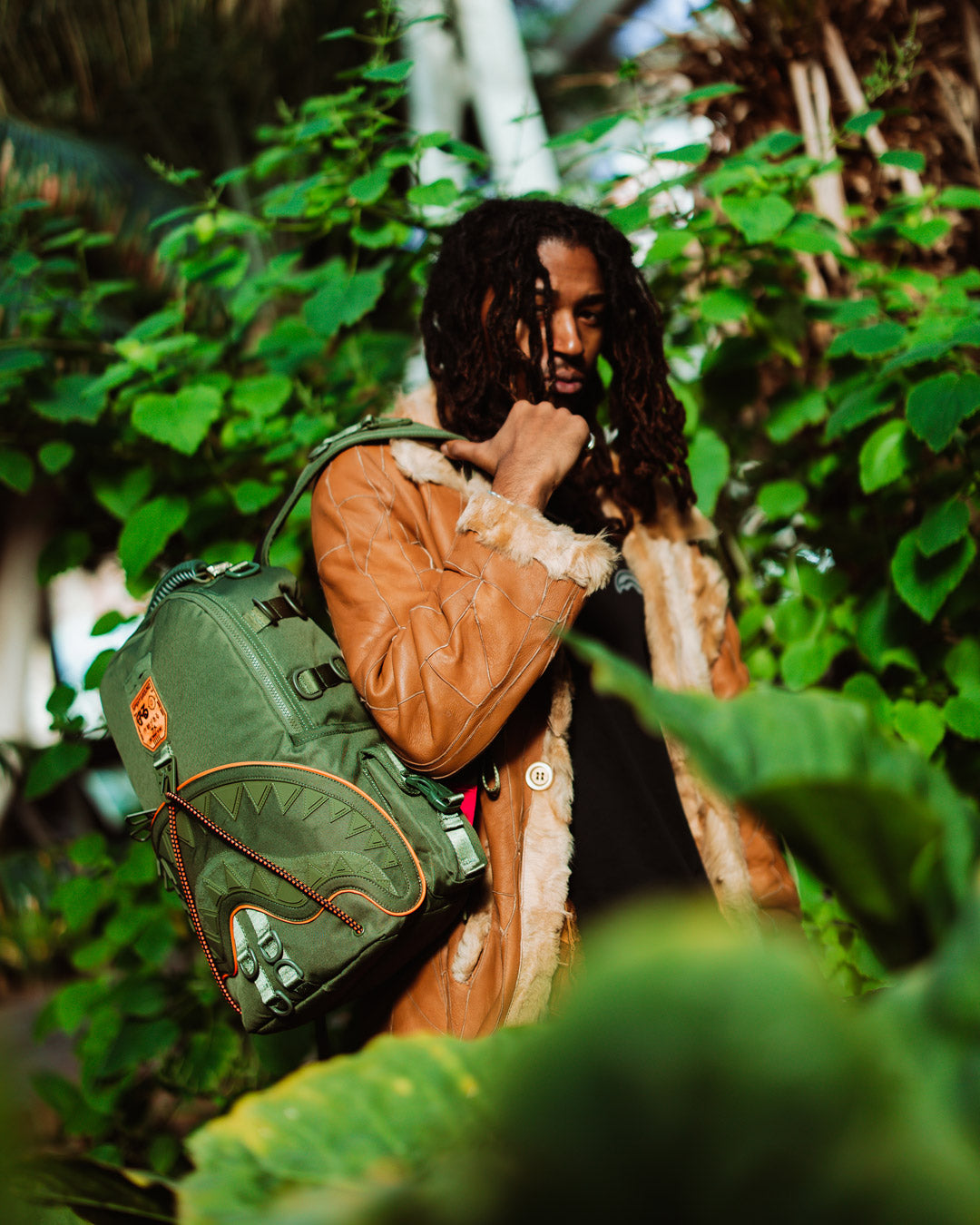 Person wearing tactical sling backpack while hiking wooded trail