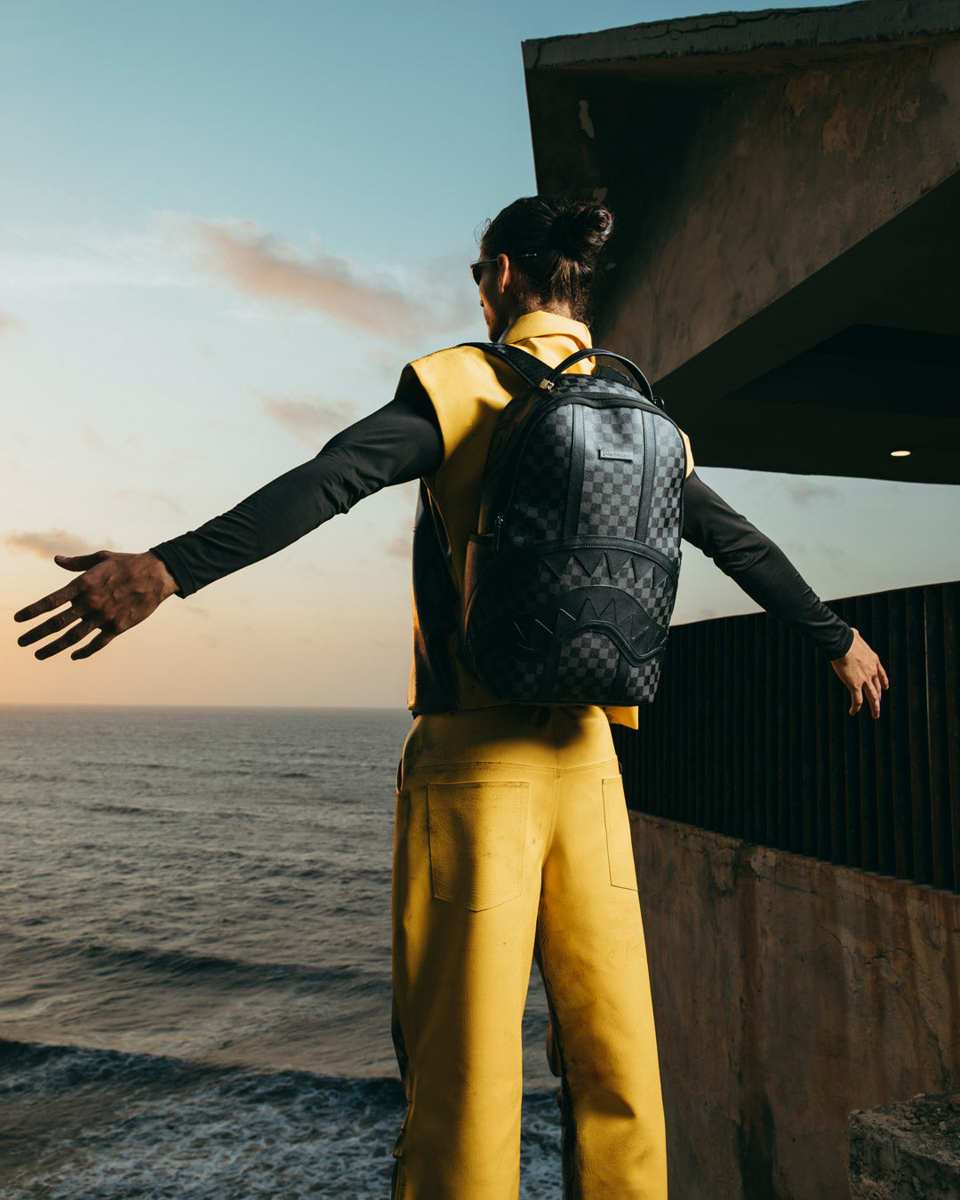Midnight Chateau backpack worn over shoulders with urban skyline backdrop