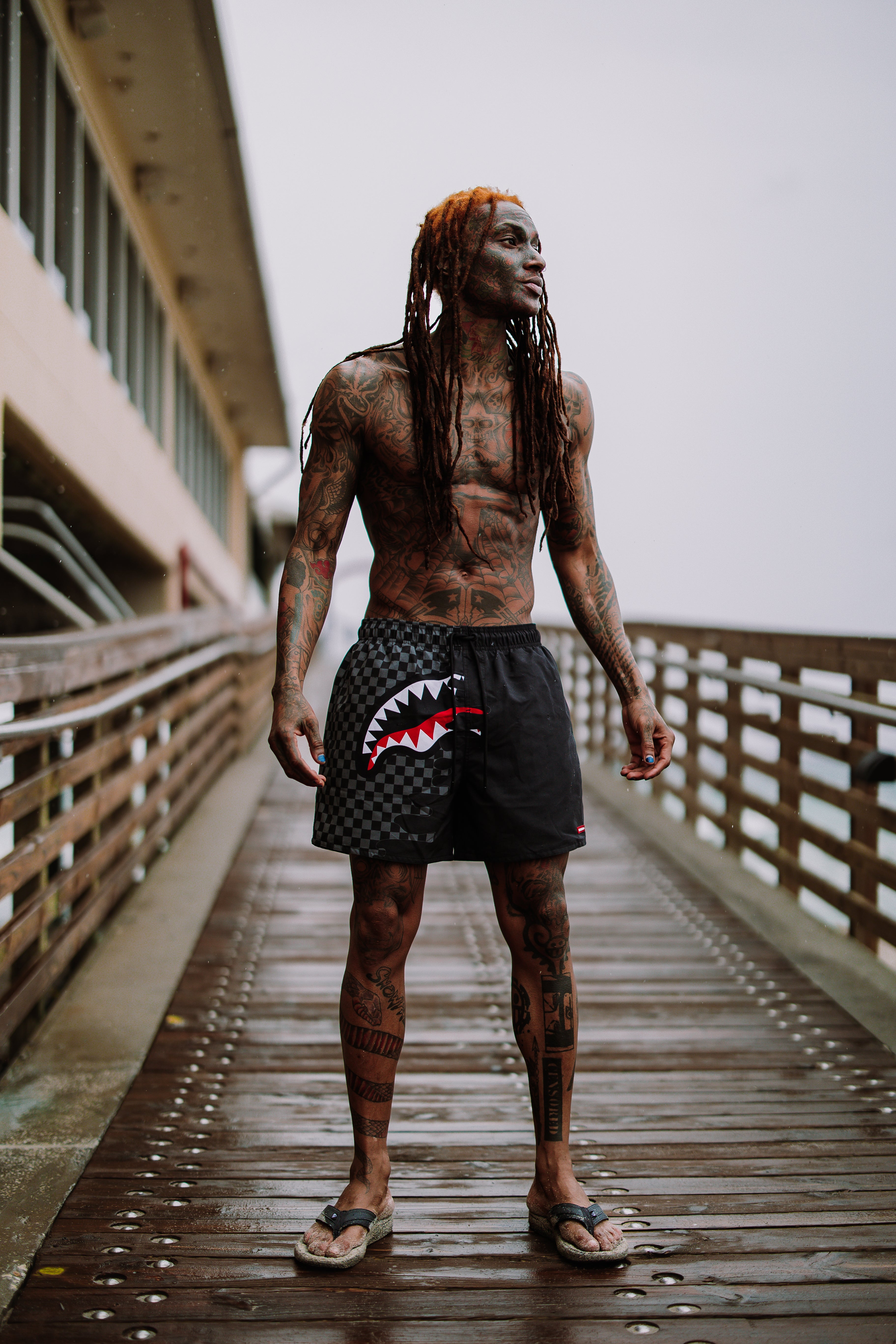 Model wearing swim with shorts while walking along East Coast shoreline