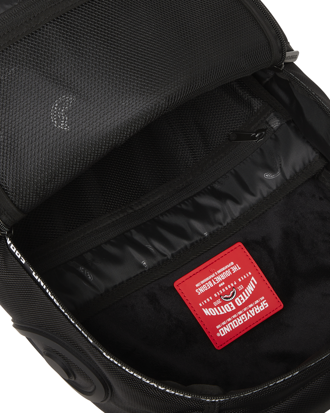 Sprayground Hero White Tape DLXR Backpack side view, showcasing its ergonomic mesh back padding and adjustable straps.