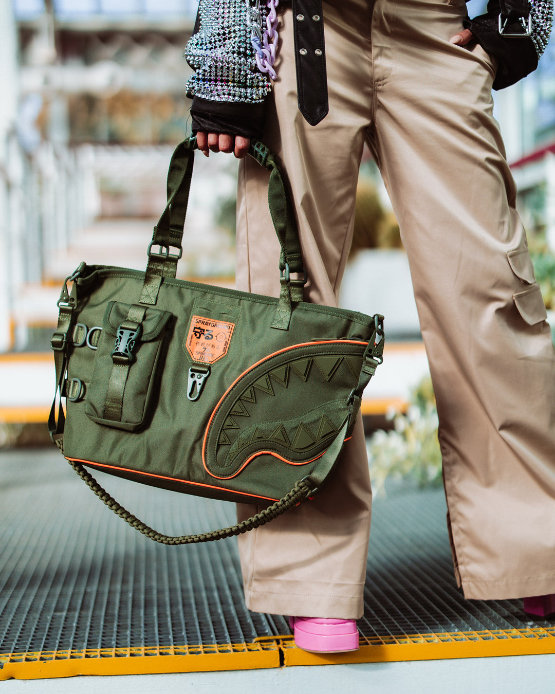 Front view of Sprayground shark tote bag on urban city street