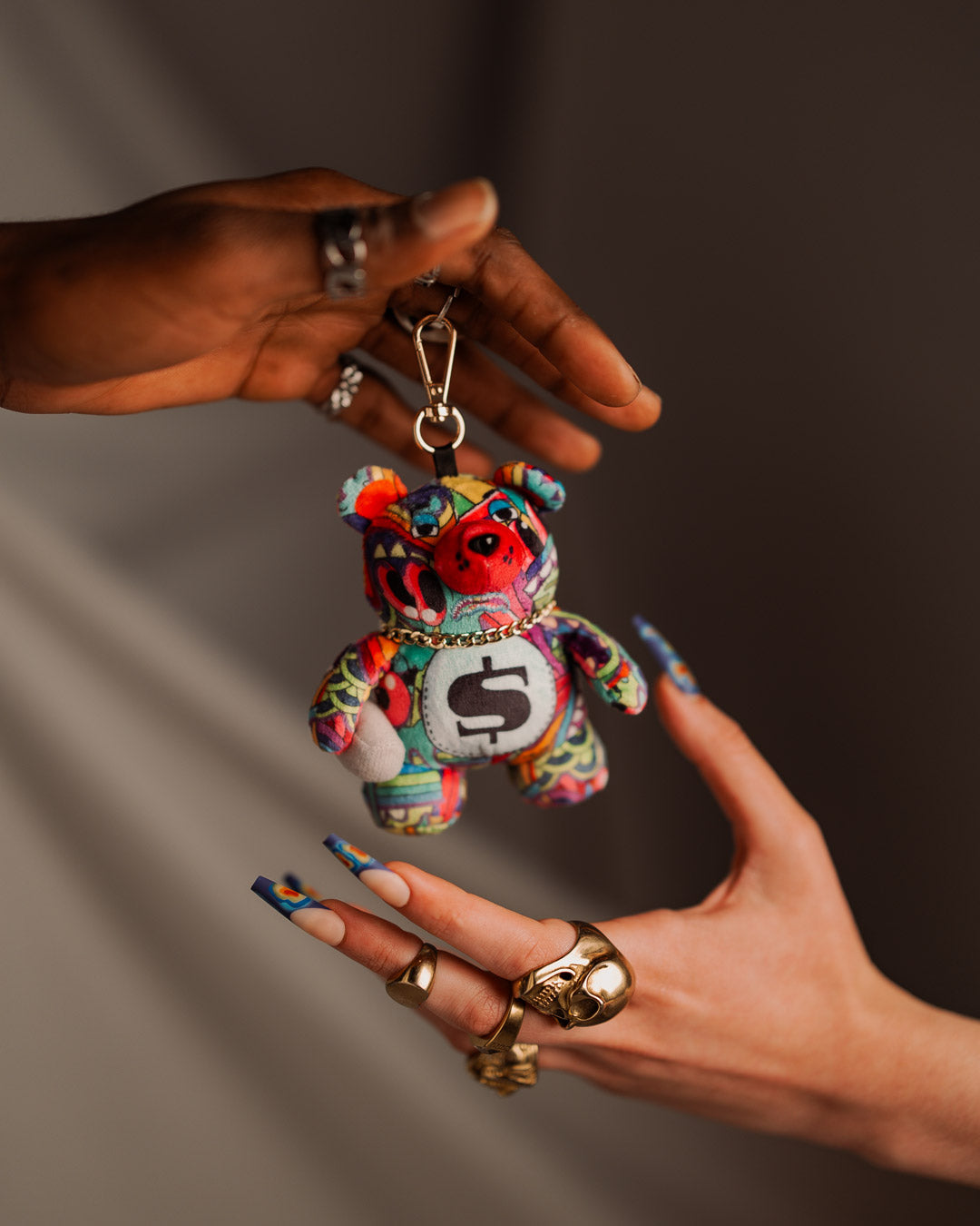 Charming bear keychain plush toy attached to a stylish handbag.