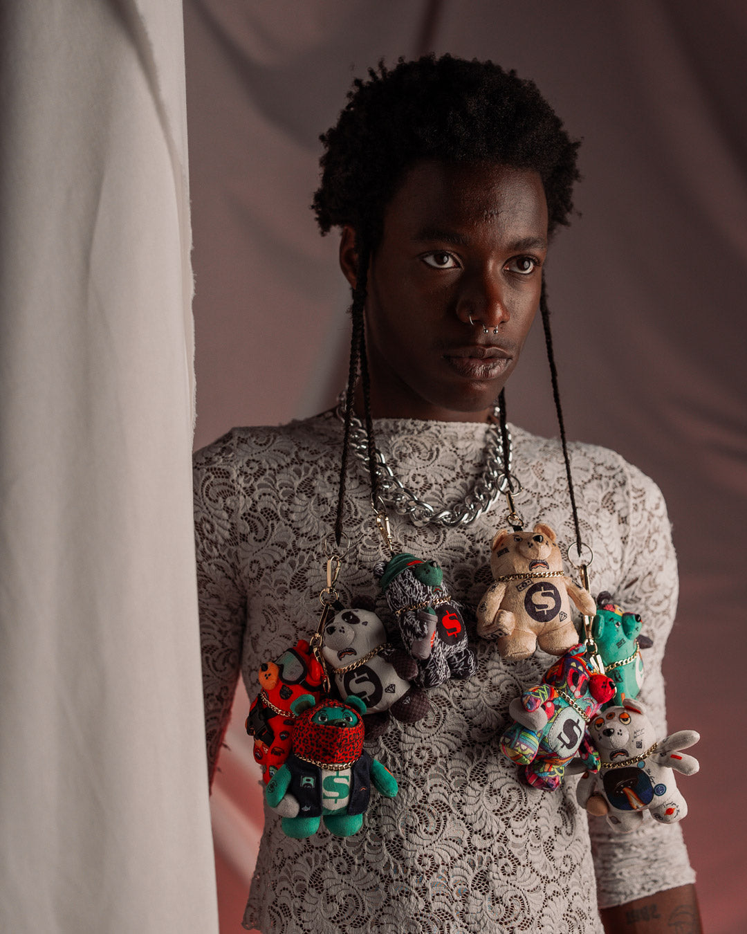 A person holding the teddy bear keychain, showing how it can be used as a bag charm.