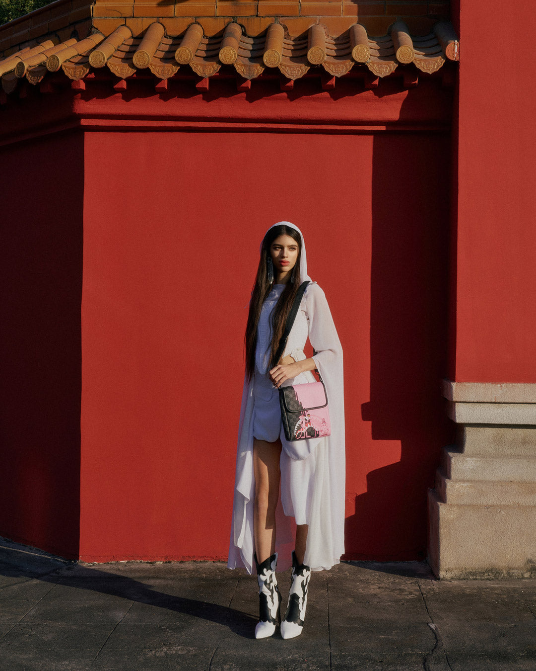 Front view of the pink sling bag showing zipper and sleek faux leather finish