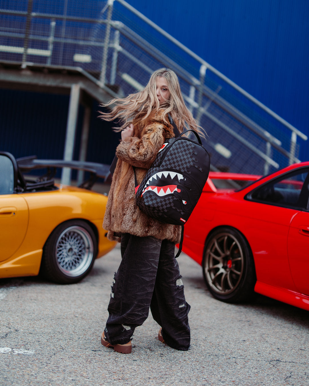 Stylish woman wearing the Speed Shark travel backpack in an urban setting