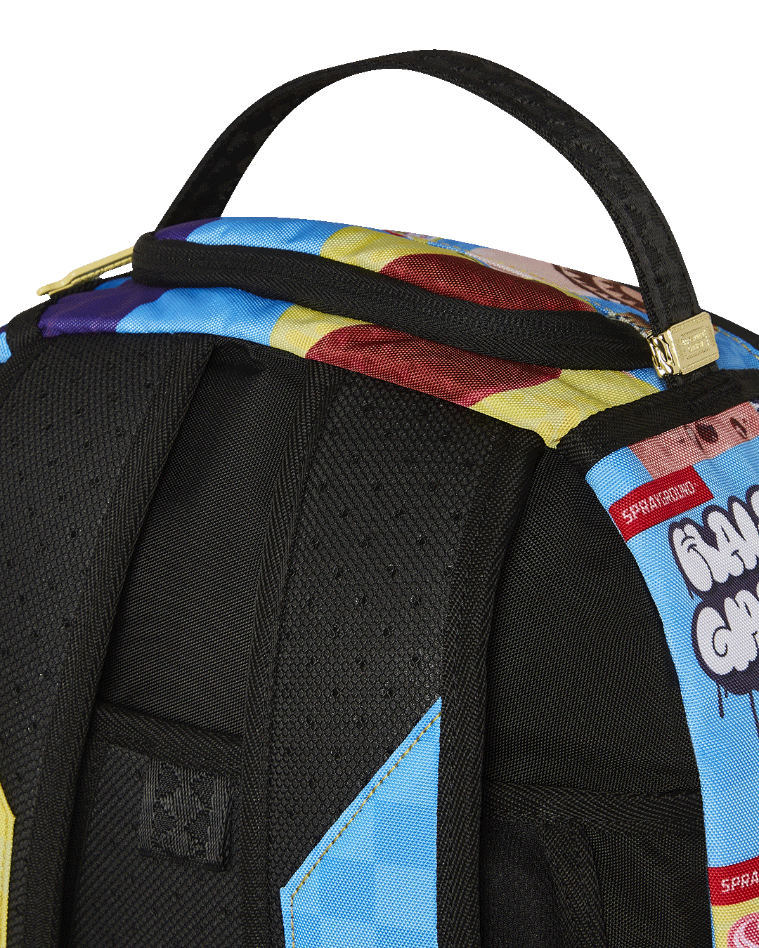 Sprayground travel backpack strapped to a rolling suitcase in an airport terminal