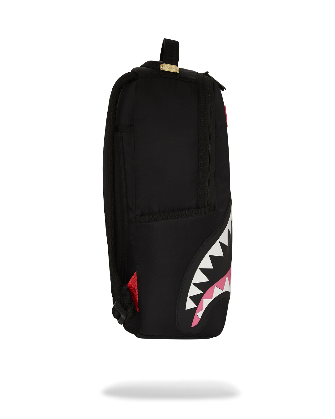 Sprayground Shark Mouth Neon Venom Backpack being used for travel, connected to a carry-on luggage