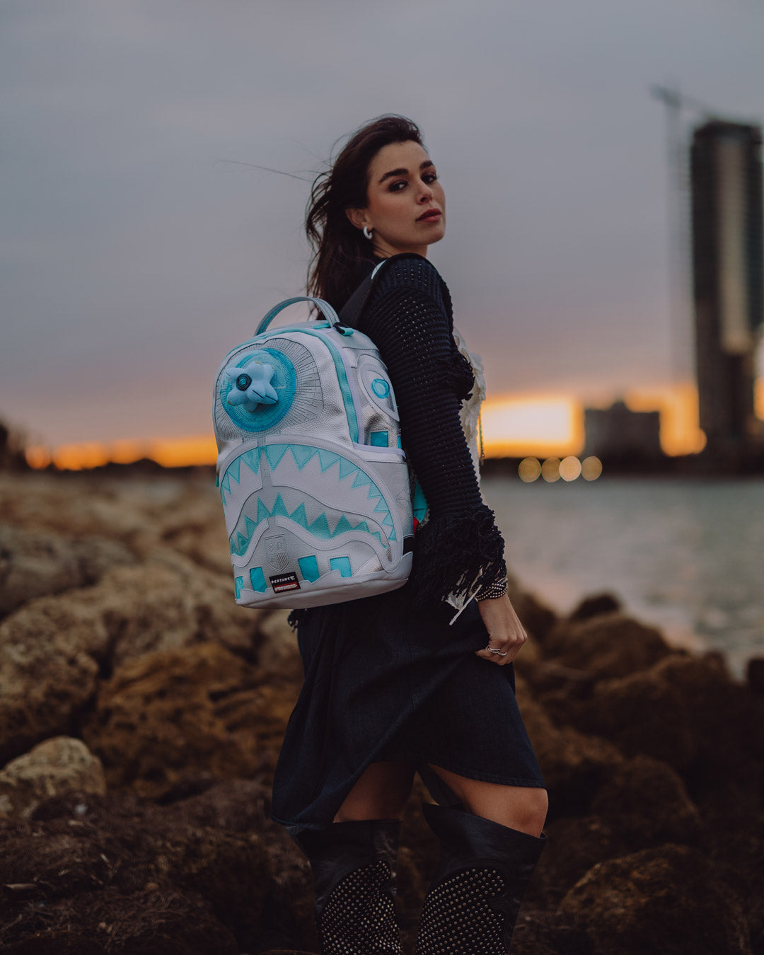 Side angle showing zippered compartments and adjustable ergonomic straps on the official collab backpack
