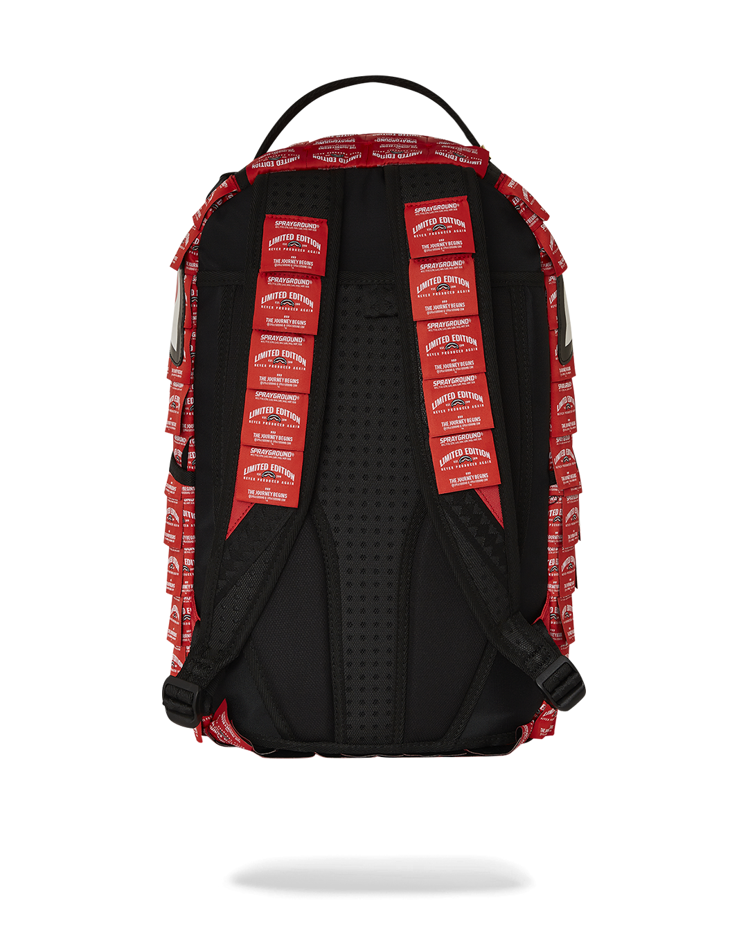 Front view of shark backpack with fringe labels and gold zippers.