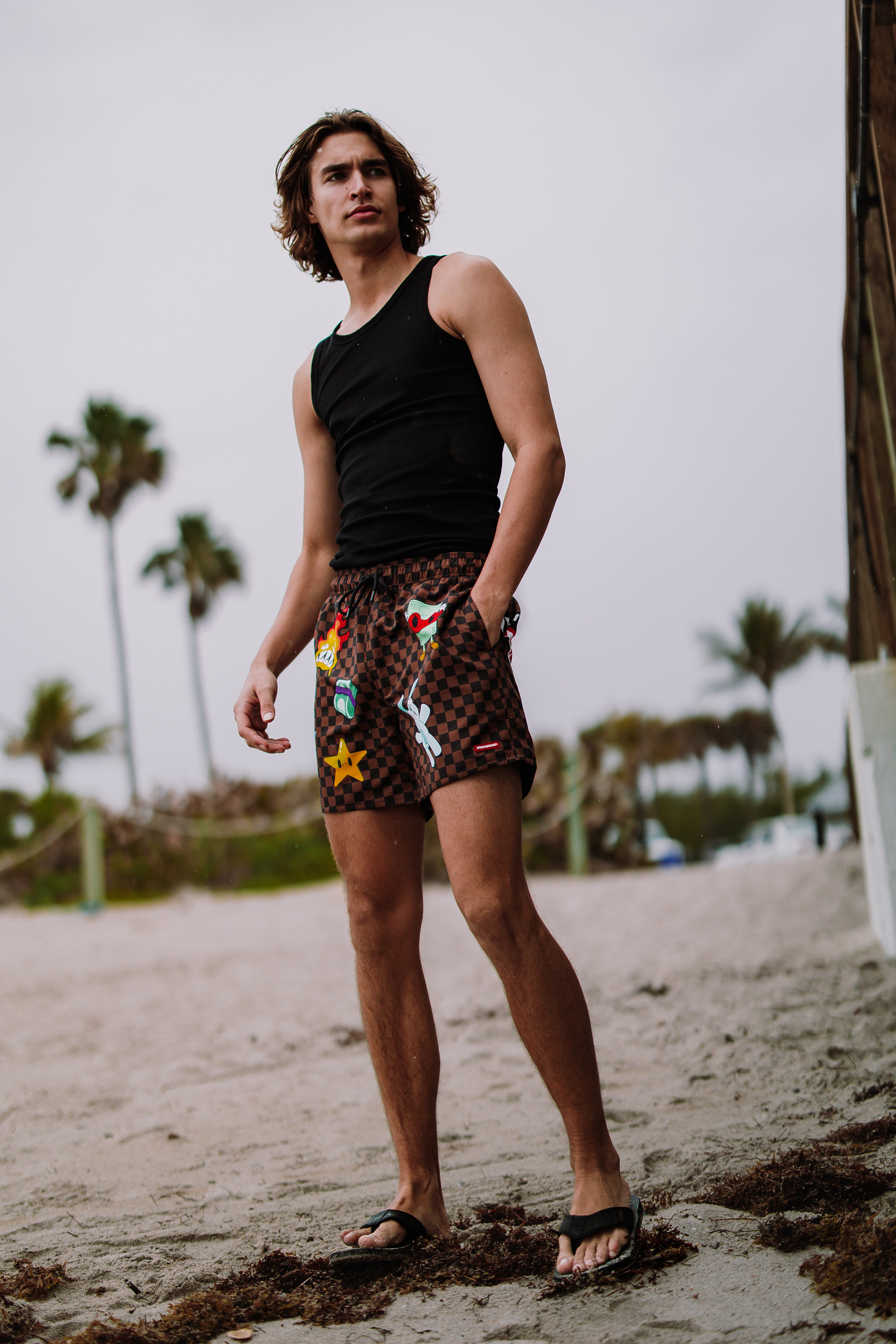 Model wearing swim shorts by the pool, perfect for summer lounging.