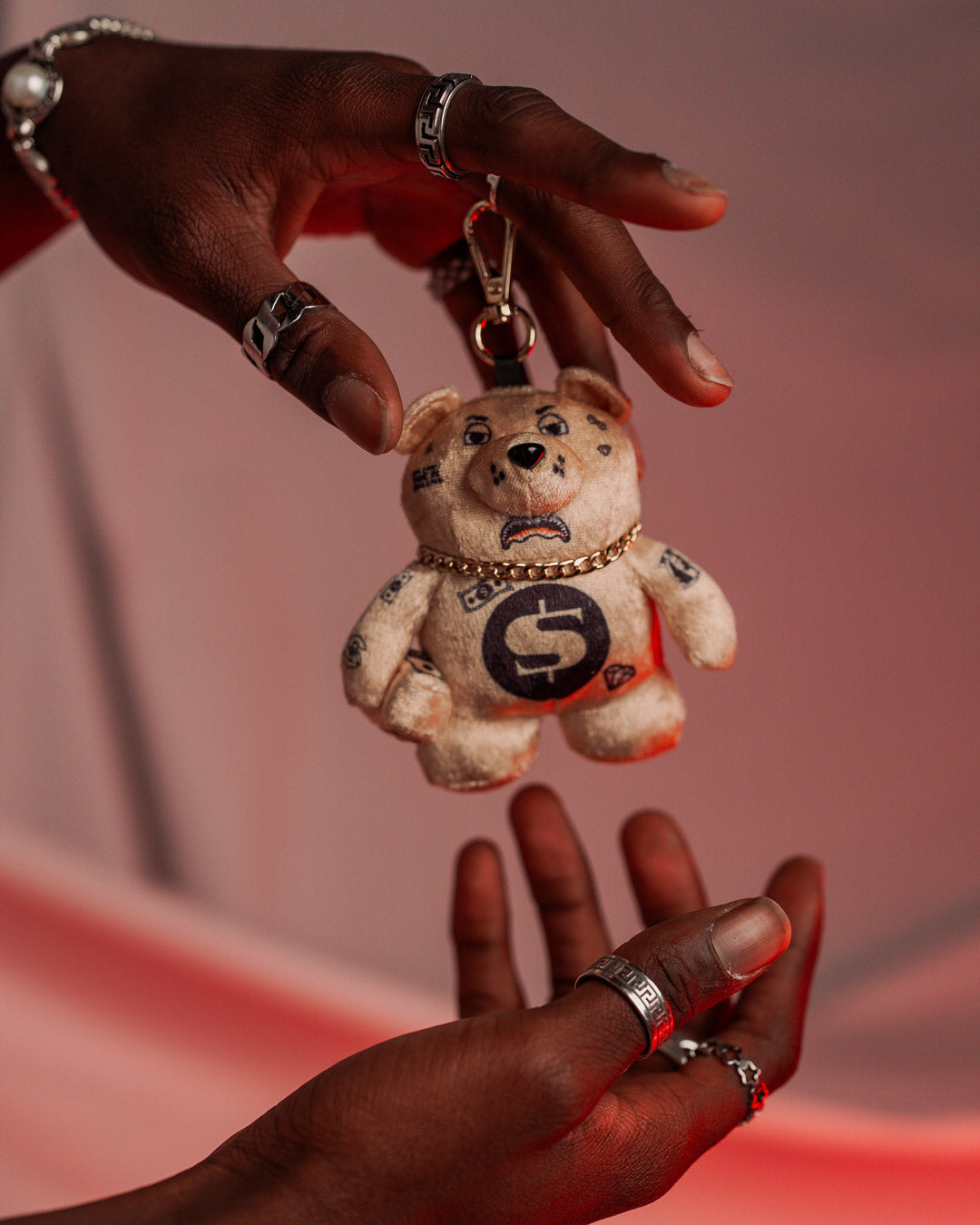 The plush bear keychain attached to a pair of keys, demonstrating its functionality.