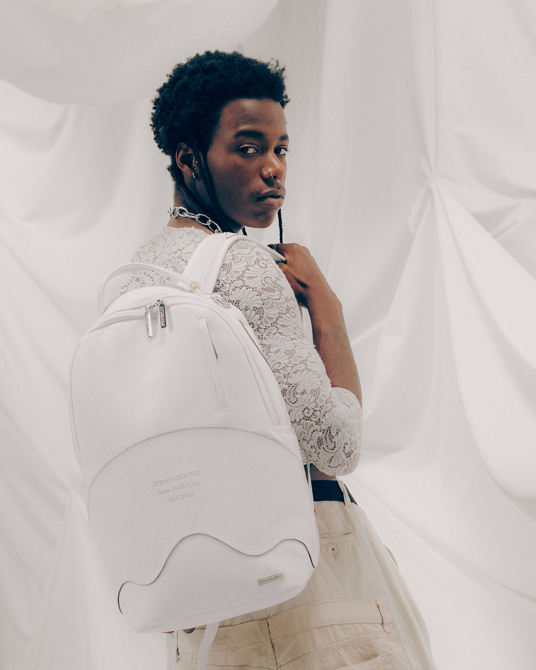 Front angle of the designer backpack showcasing sharkmouth shape and silver foil logo.