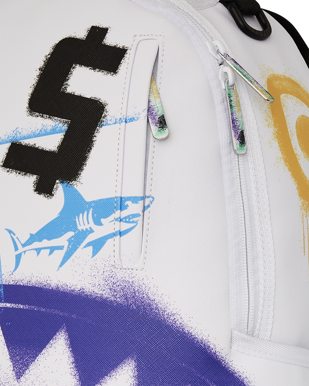 Close-up of backpack’s gold zippers and sprayground badge detail