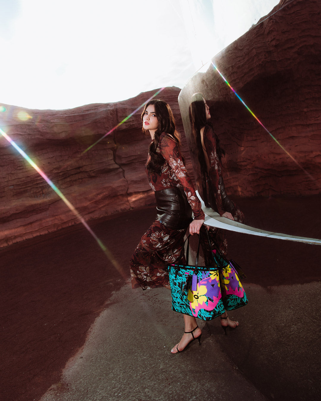 Model carrying the designer tote crossbody style with urban backdrop