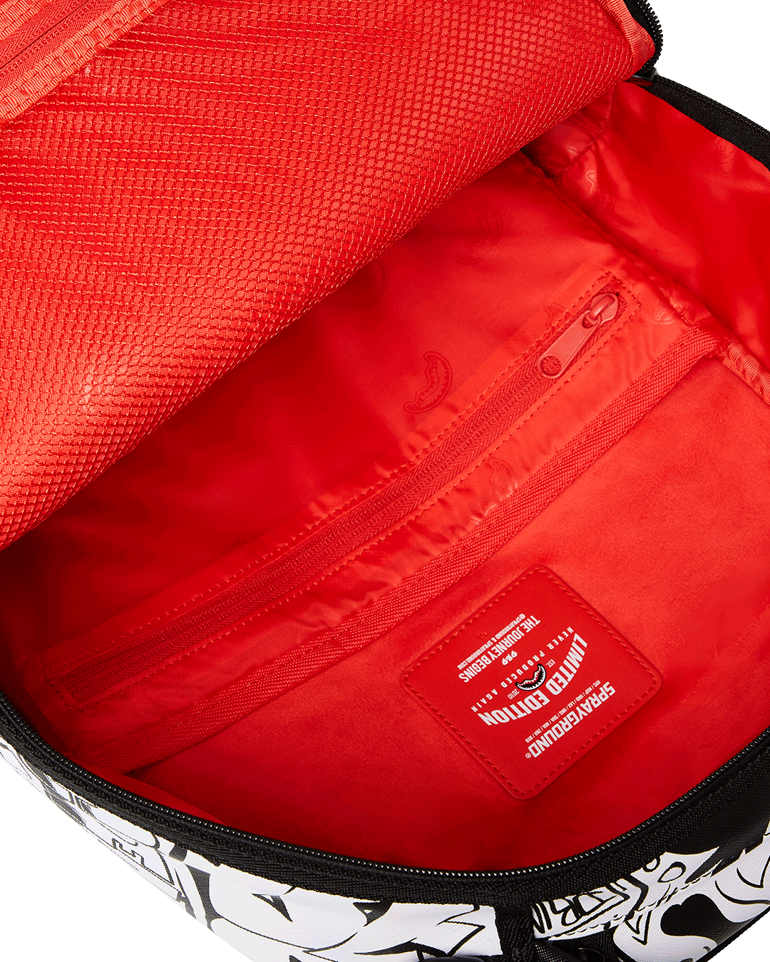 Doodle King backpack attached to rolling luggage, highlighting the slide-through sleeve.