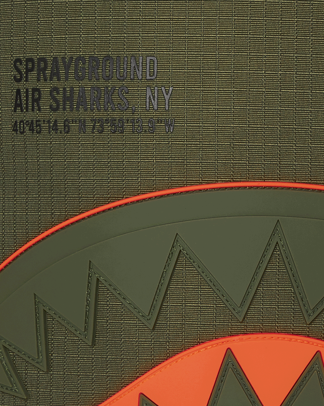 Closeup of shark backpack front showing rubber mouth and gold zipper
