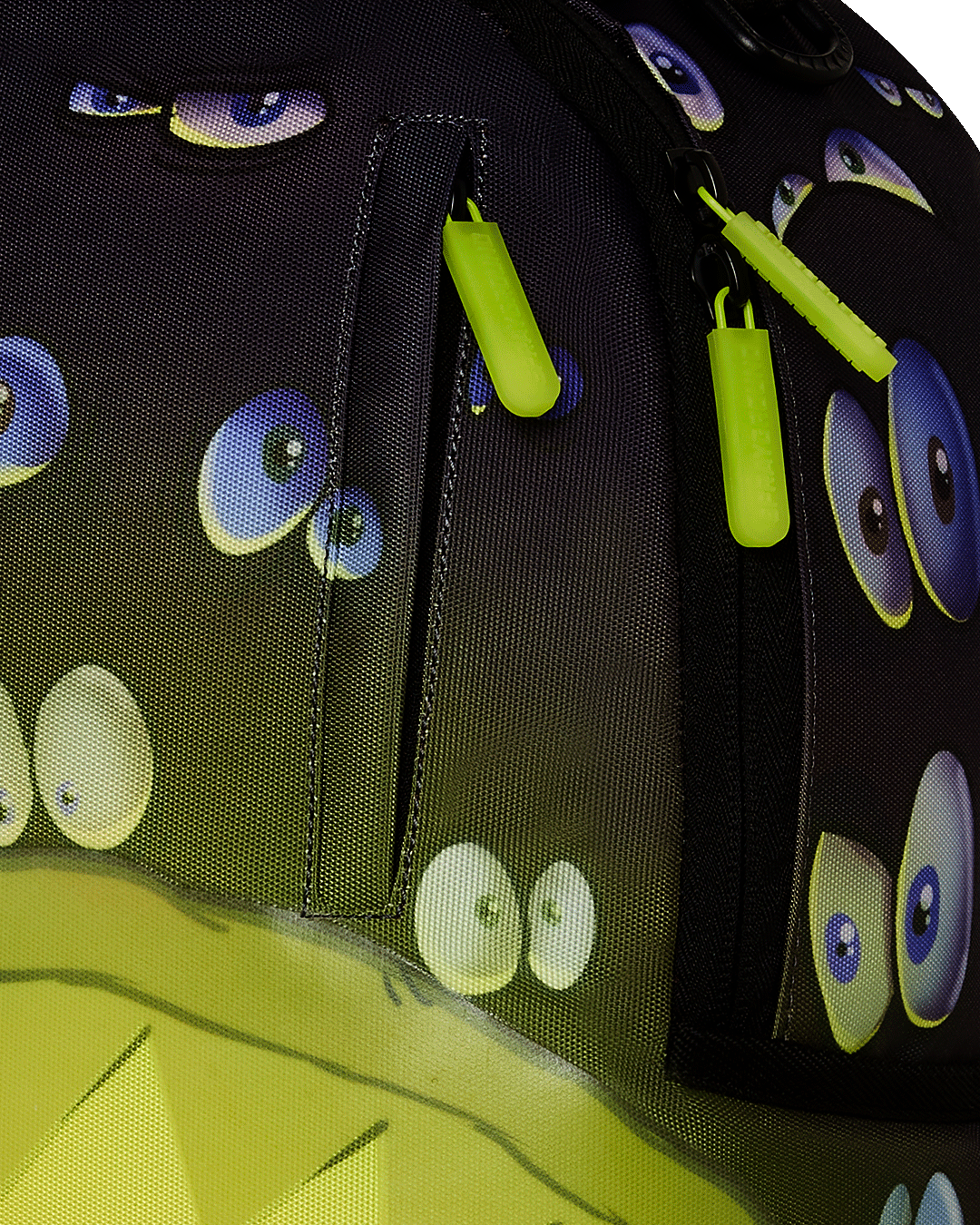 Close-up of gold zippers and Sprayground badge on designer backpack.