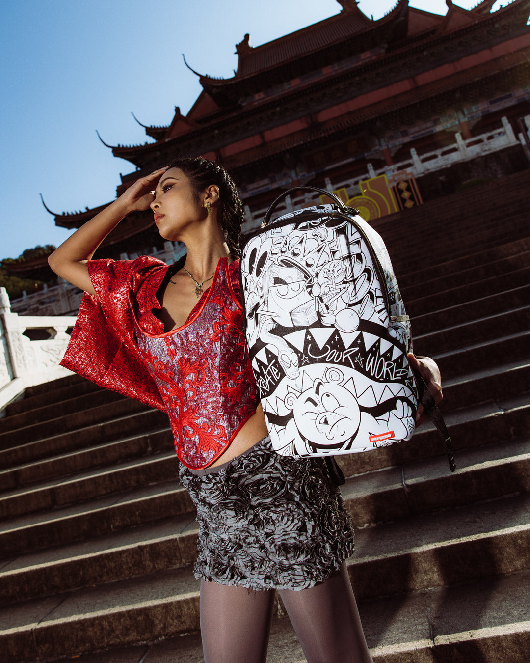 Doodle King backpack attached to rolling luggage, highlighting the slide-through sleeve.