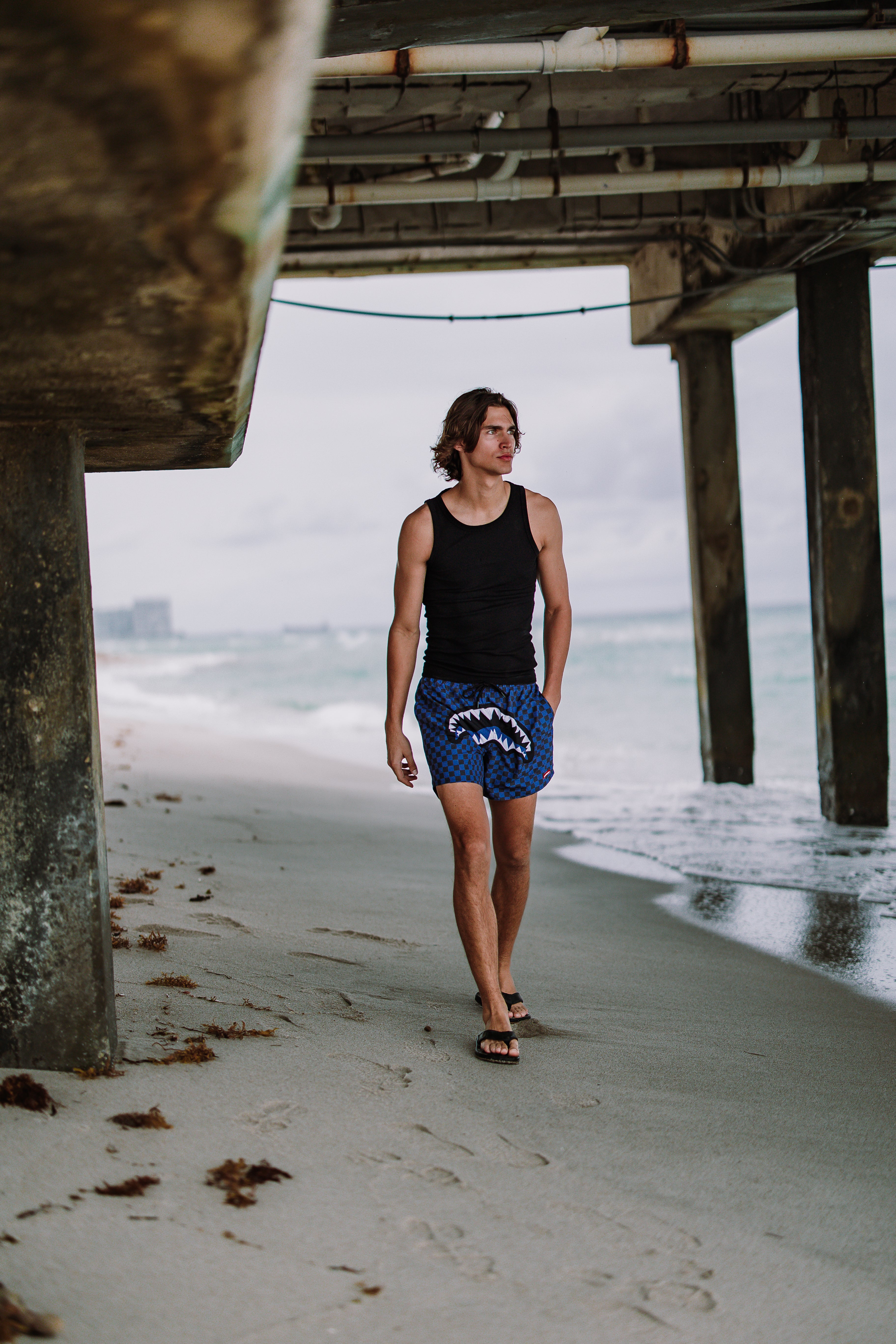 Woman wearing Parisian Nights Swim Shorts, walking along the beach