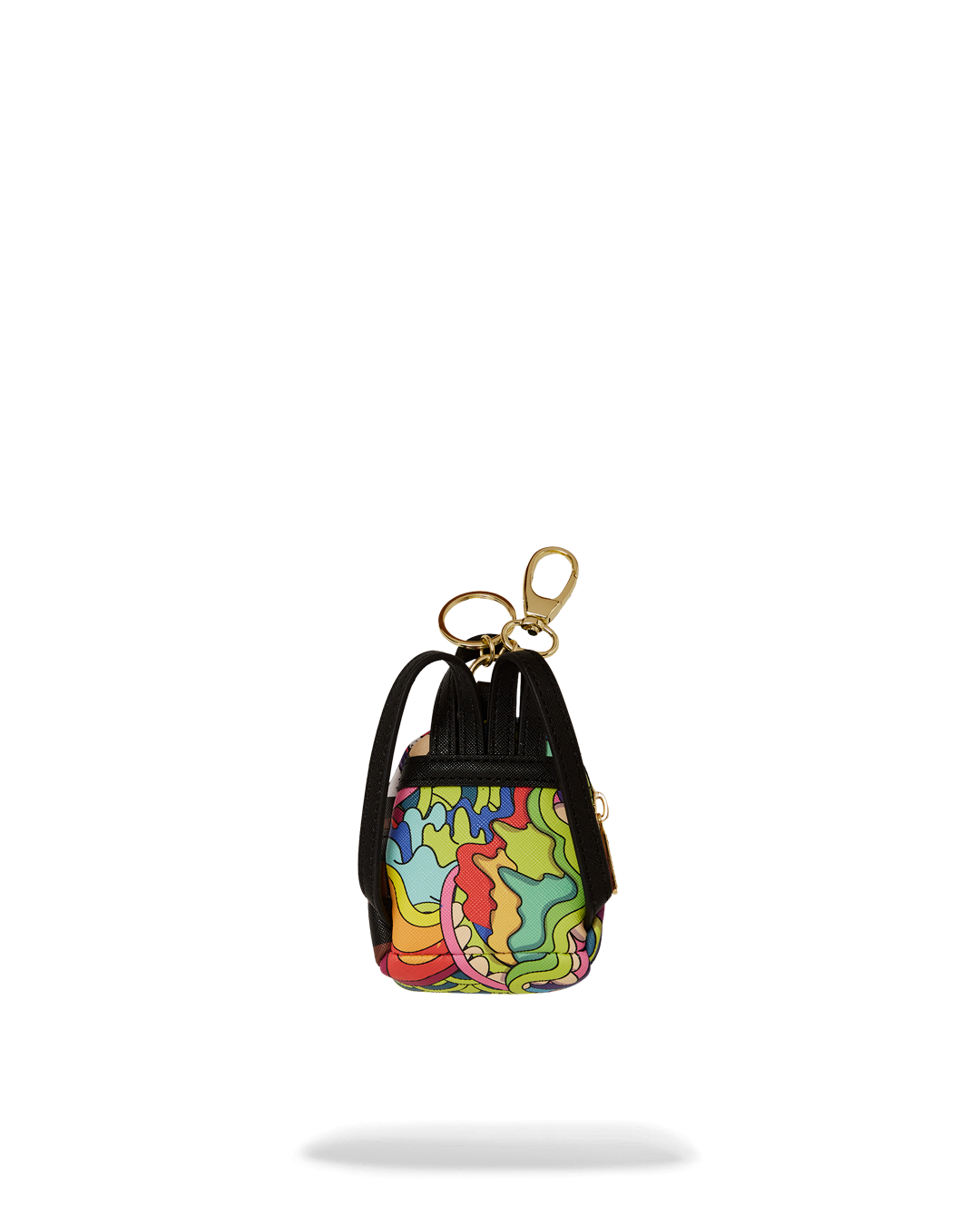 The keychain mini backpack being used to store small items like coins and headphones.