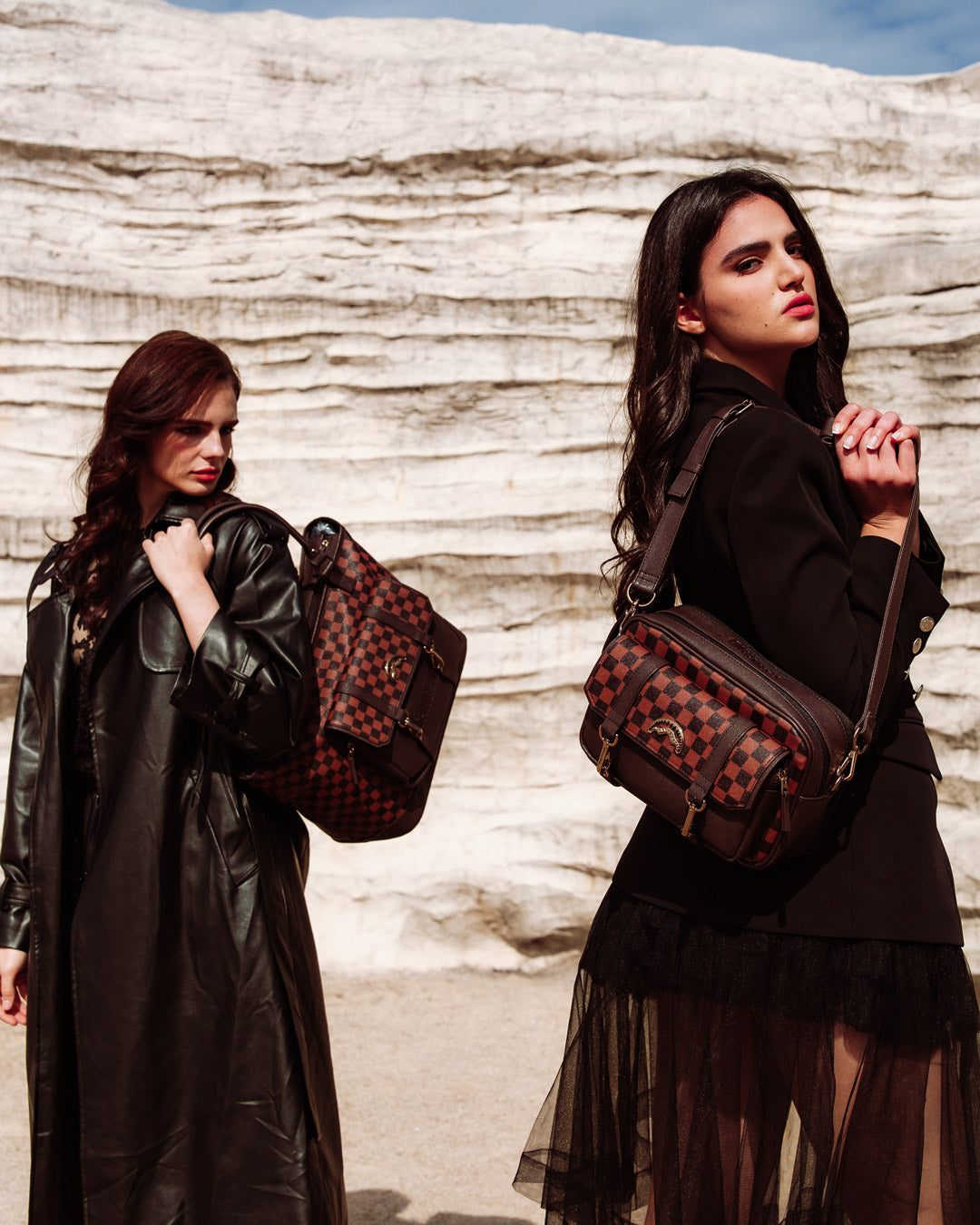 Model wearing leather crossbody bag slung across shoulder in a city park