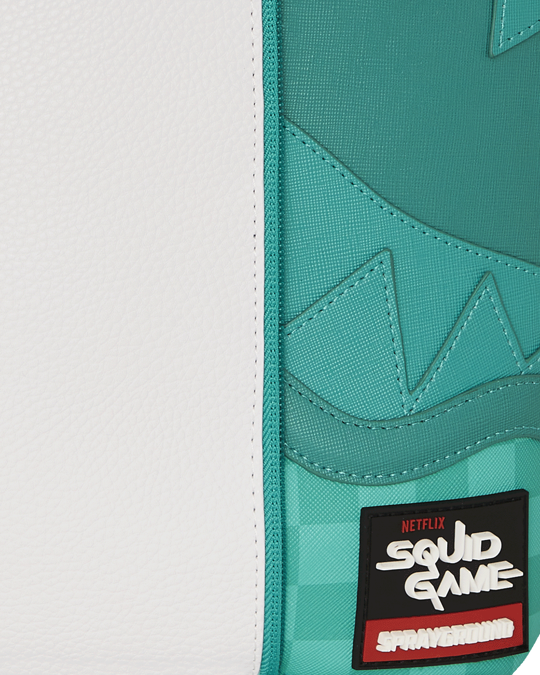 Close-up of the gold zippers and detailing on the Sharkmouth faux leather backpack.