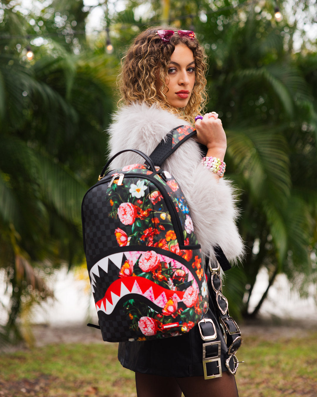 Sprayground faux leather backpack worn by a woman in an urban setting