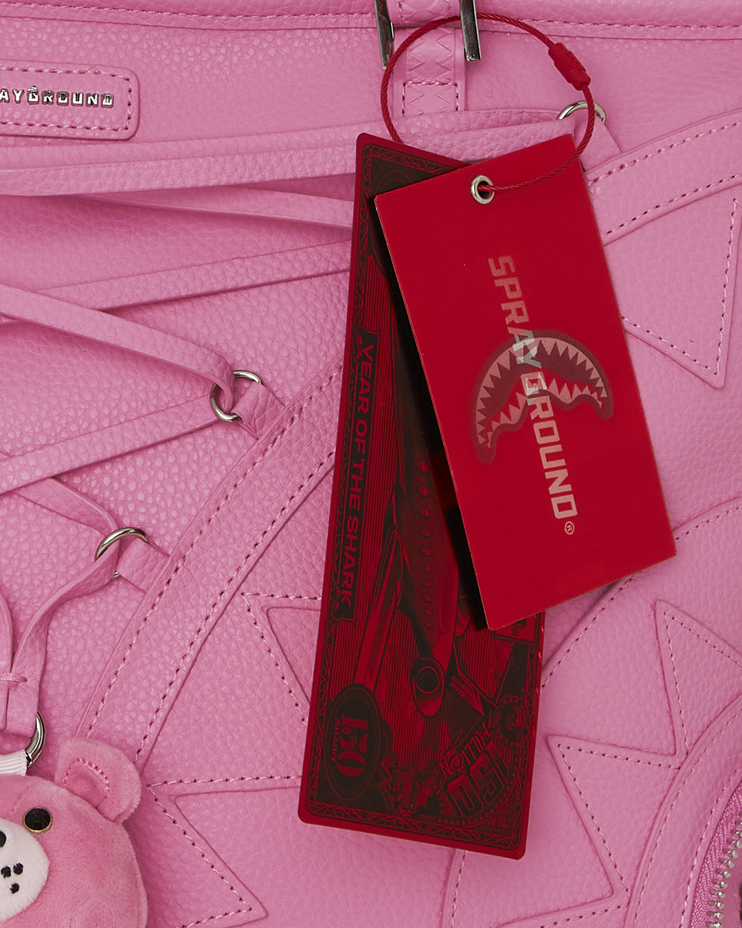 Sprayground faux leather tote bag shown front view with studded details