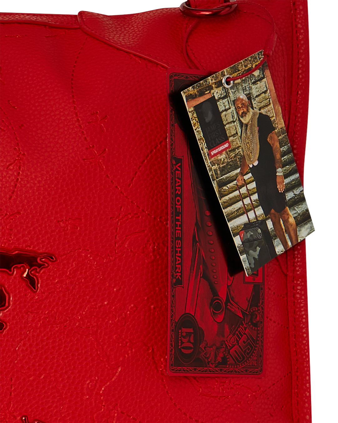 Close-up of the James First Class Ruby Red faux leather duffle bag showing its textured exterior