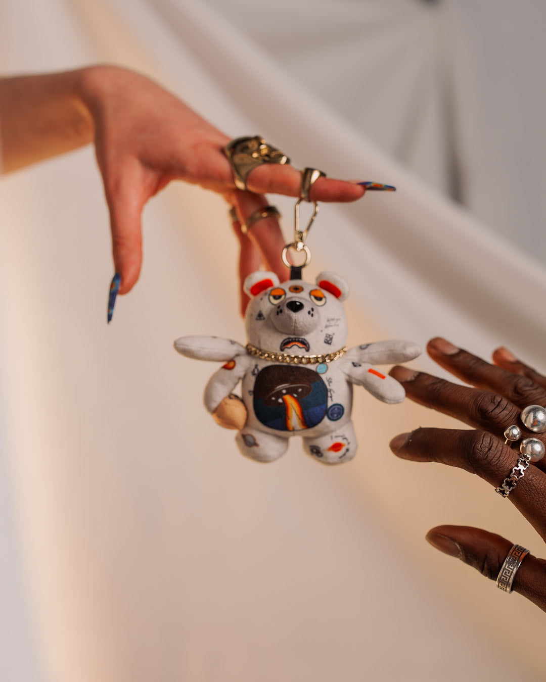 Cute teddy bear plush keychain with space-inspired design on a set of keys
