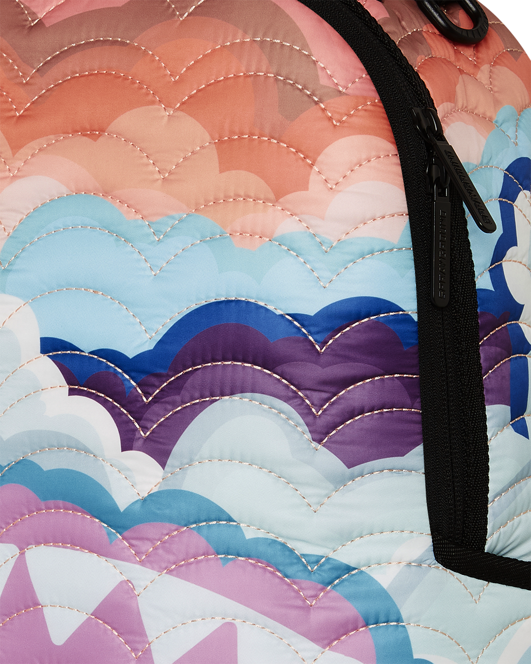 Rainbow quilted backpack worn over shoulders, showcasing cloud detailing and side pockets