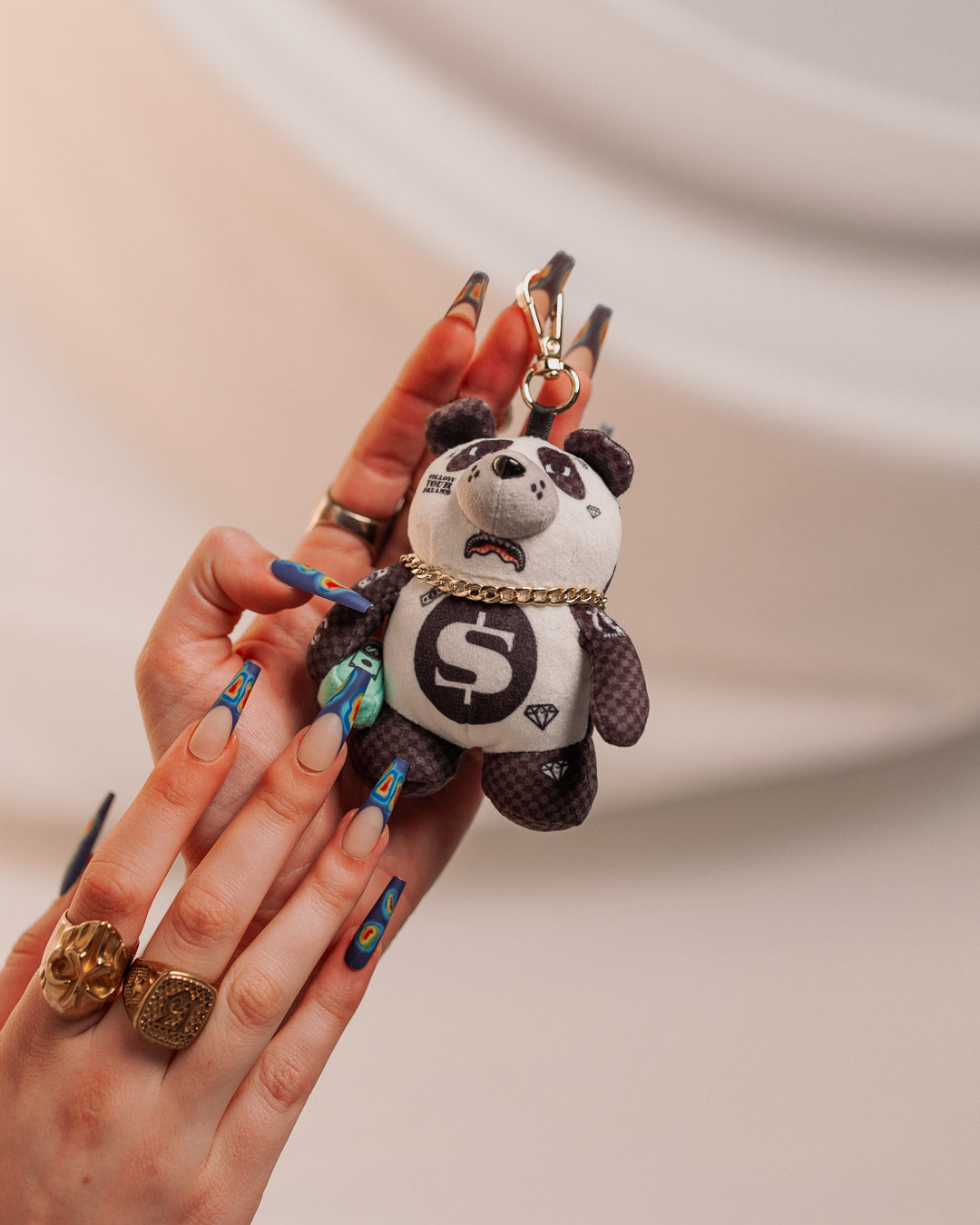 Teddy bear keychain attached to a bag zipper.