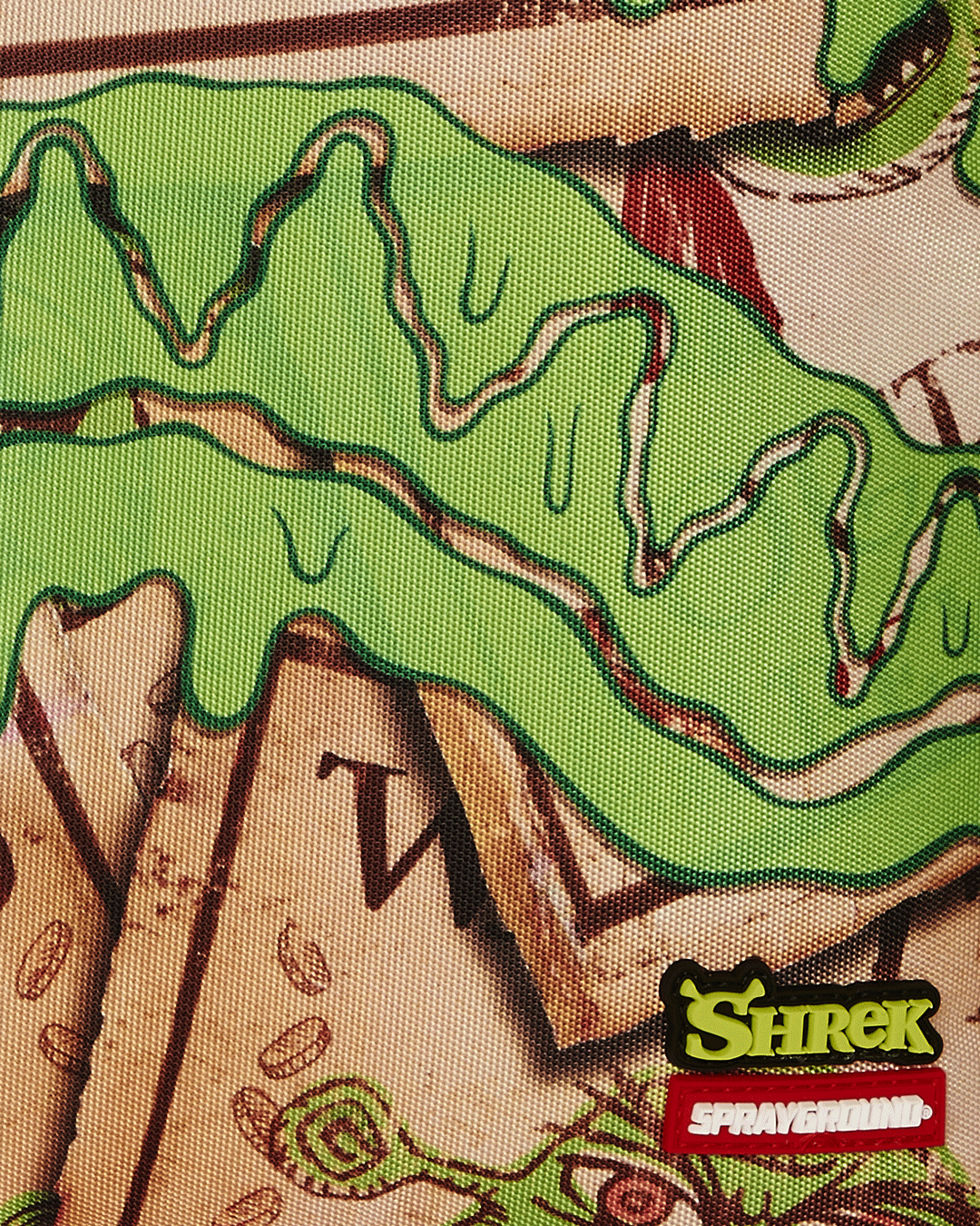 Sprayground SHREK WANTED backpack in use, connected to carry-on luggage