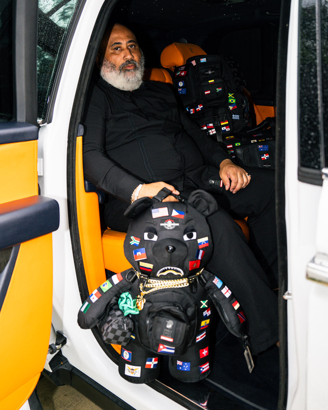 Side angle of the limited edition sprayground teddy bear backpack showing adjustable straps and zippered pockets.