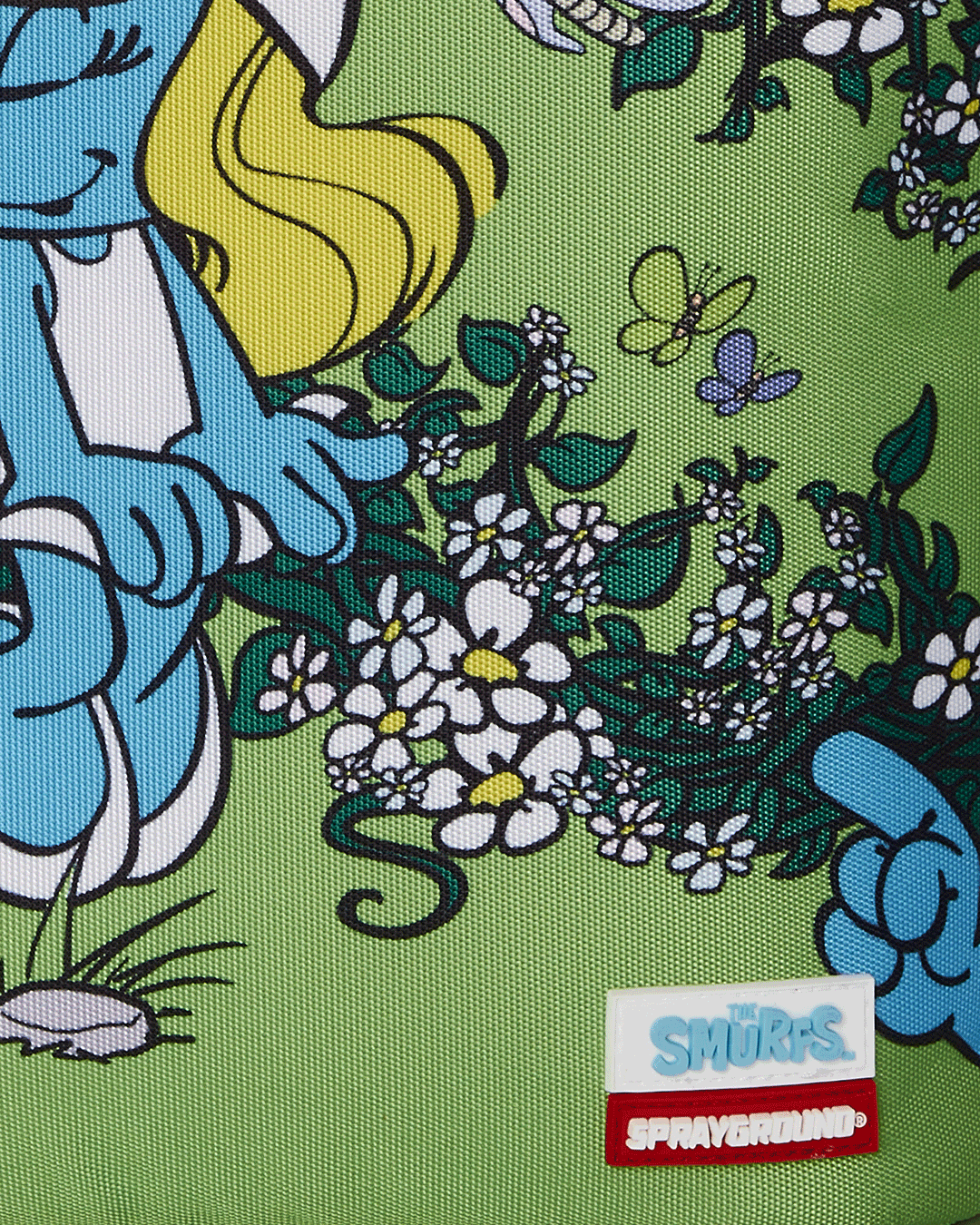 Child wearing Smurfs cartoon backpack during outdoor play.