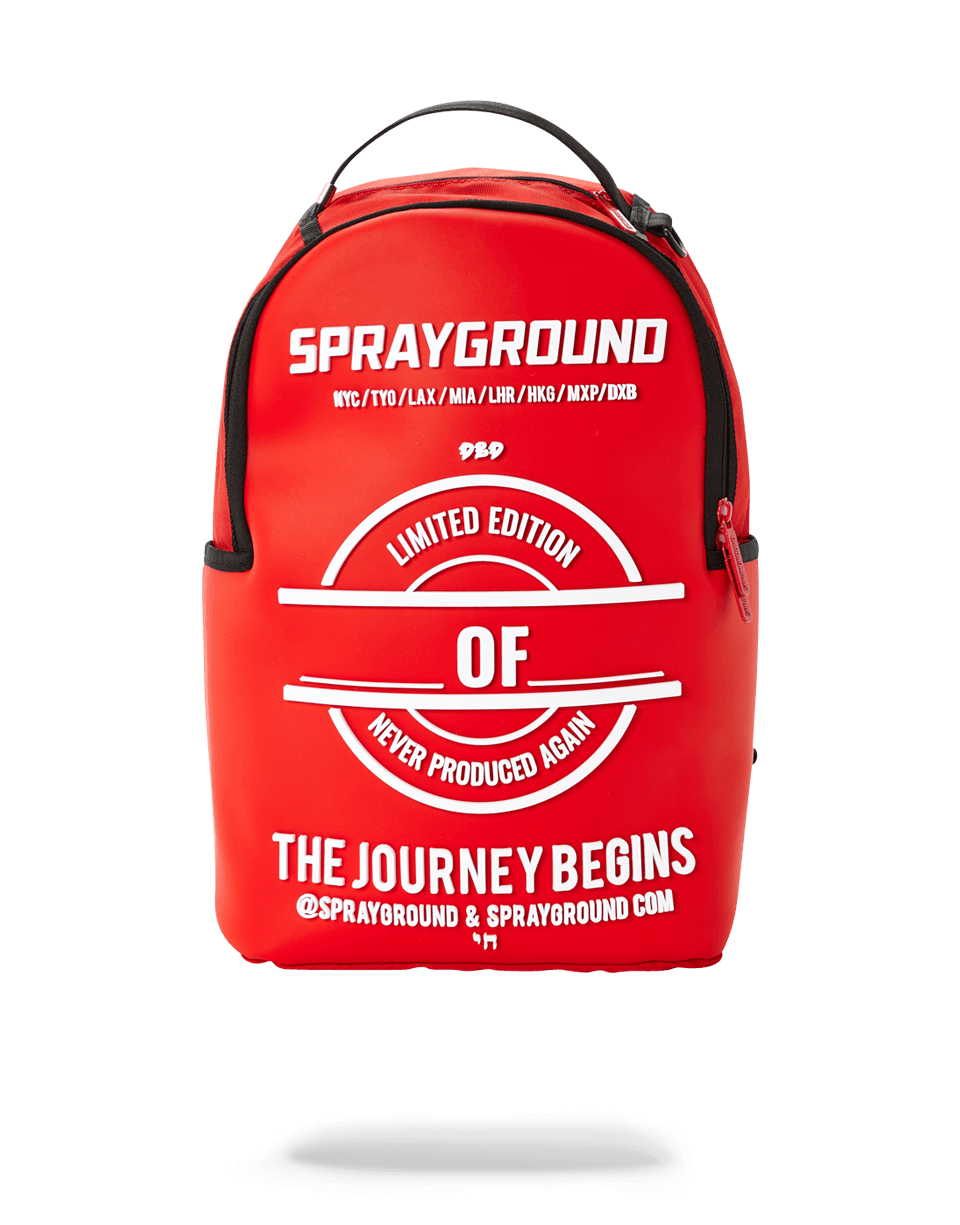 Side view of Sprayground backpack pink resting on travel gear near the Oregon coast.