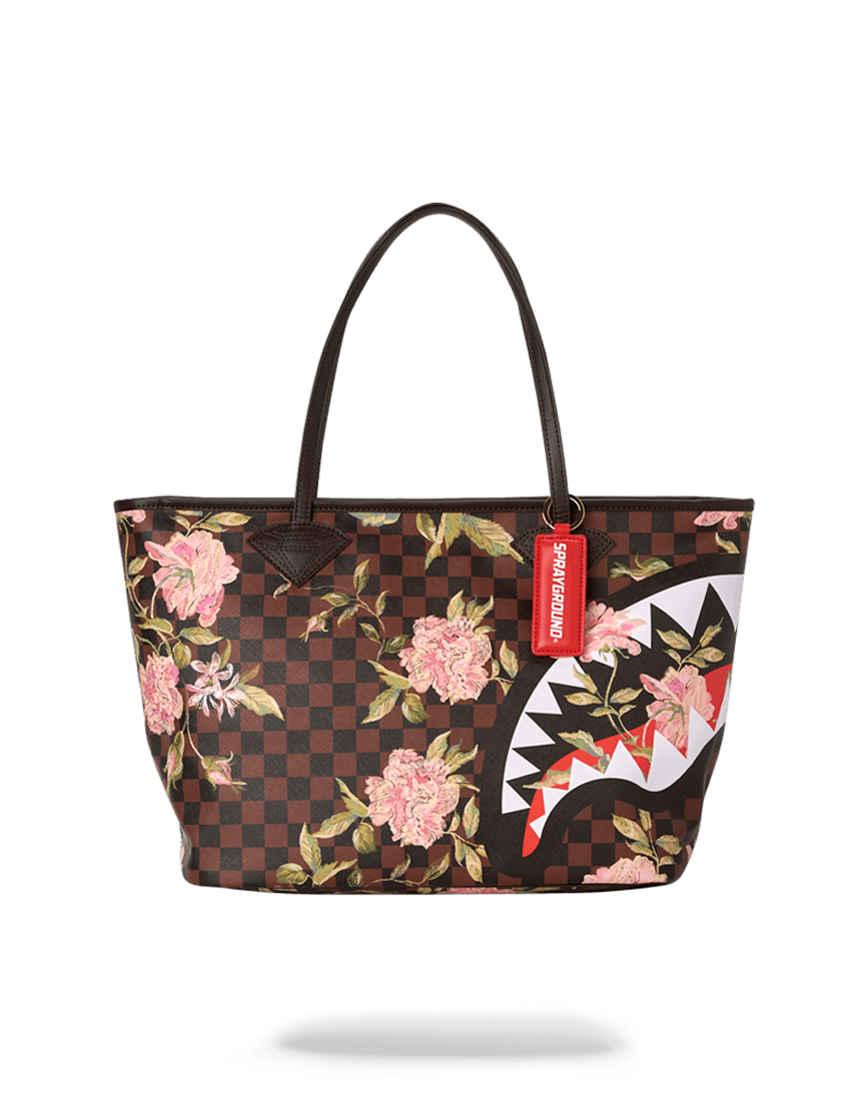 Sprayground tote bag in use, slung over a shoulder with urban backdrop