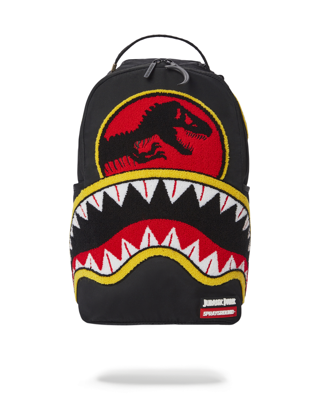 Jurassic Park Shark backpack front view, showcasing the front zipper pocket and Sprayground Authentic badge