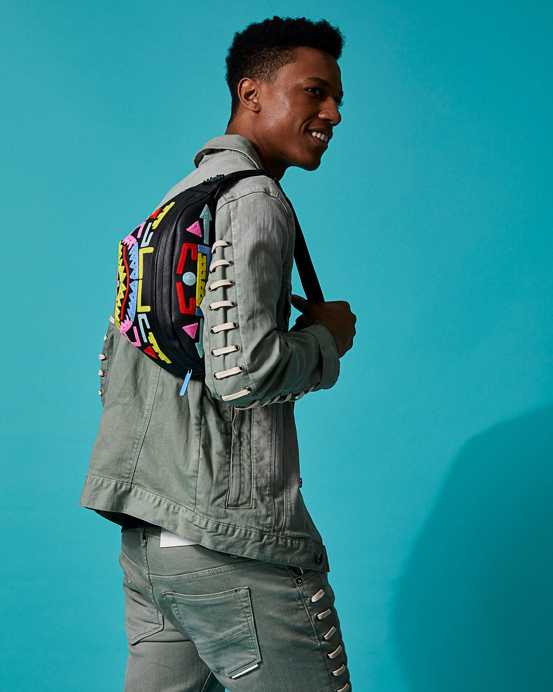 Sprayground crossbody waist bag with red zippered pocket and metal buckle hardware