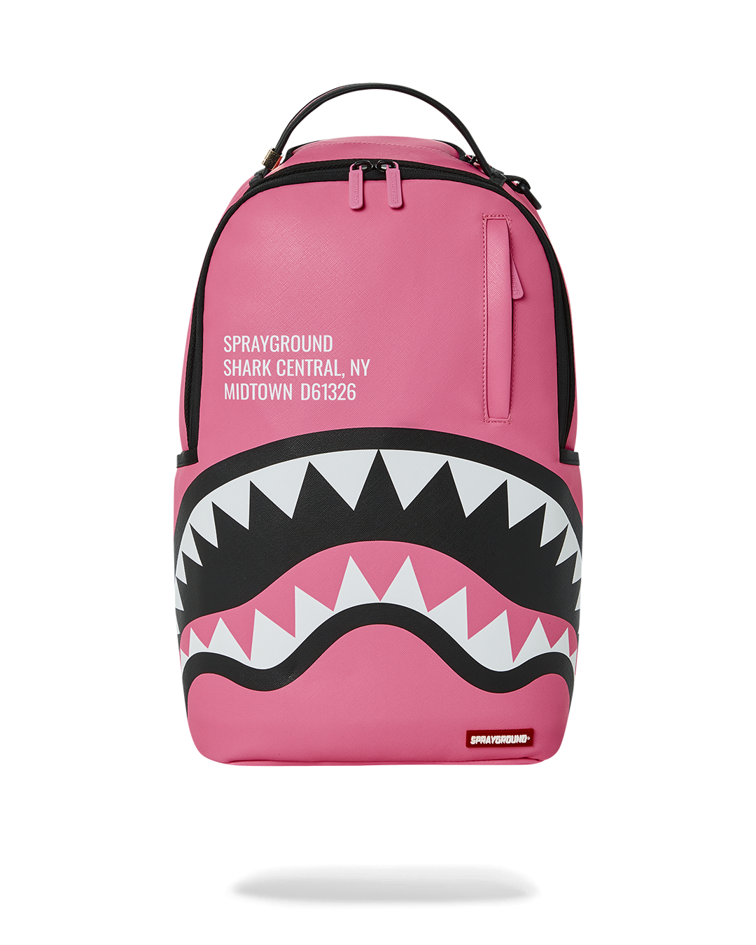 Front view of the Sprayground pink backpack showing shark motif and gold hardware.