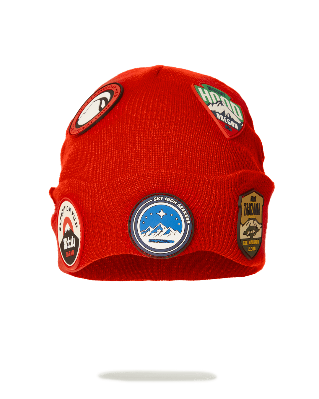 Front view of Sprayground beanie with embroidered mountain patches, worn during a hike.