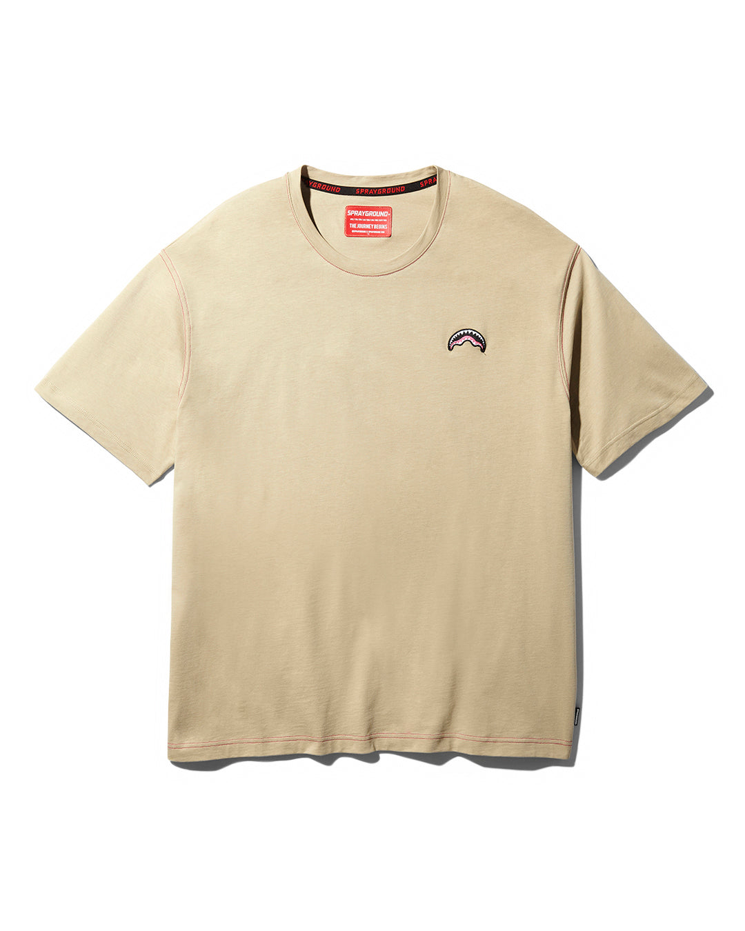 Front view of the over shark graphic tee in sand color, highlighting the embroidered logo
